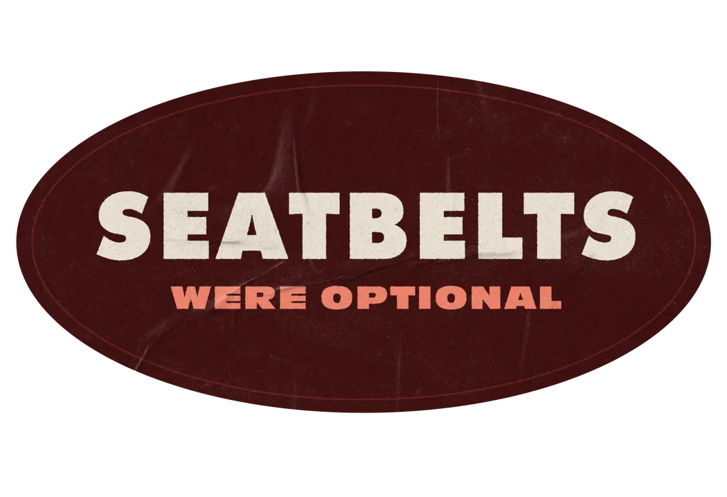An oval sticker reading “Seatbelts were optional”